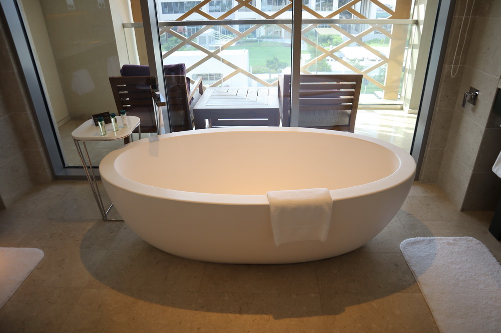 a white bathtub in a room with glass doors