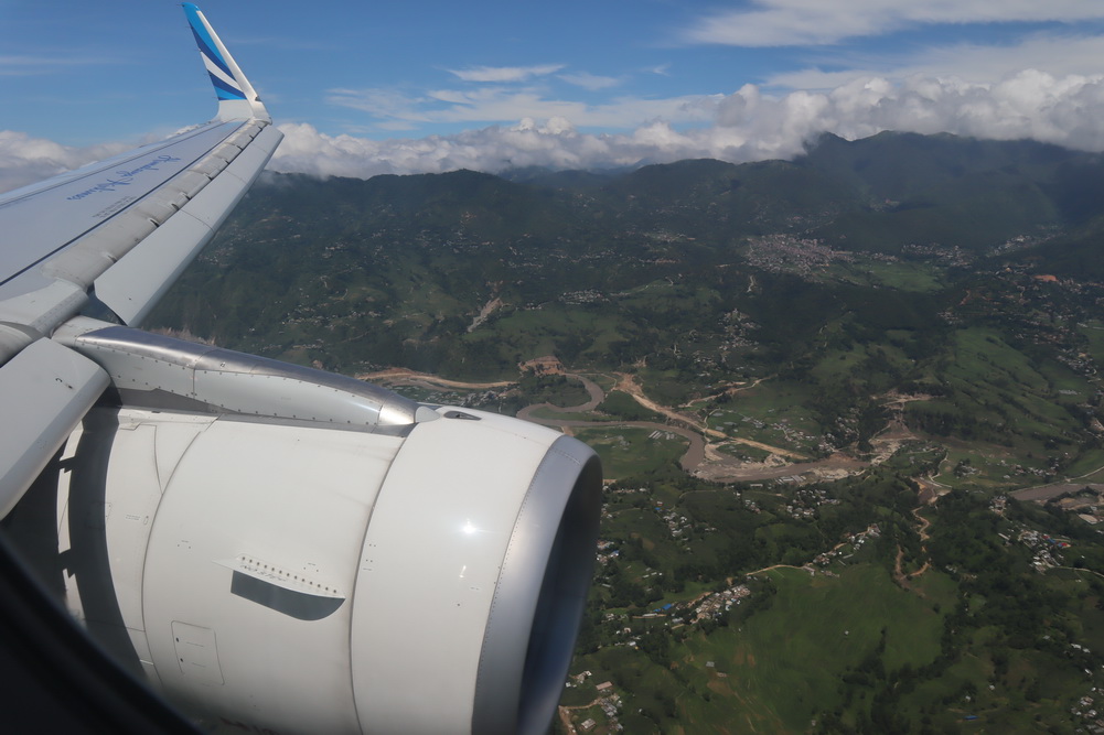 an airplane wing with a landscape in the background