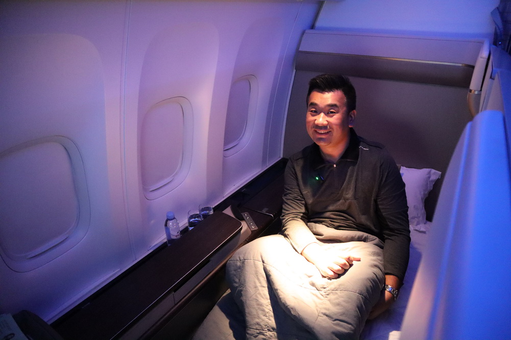a man sitting on a bed in an airplane