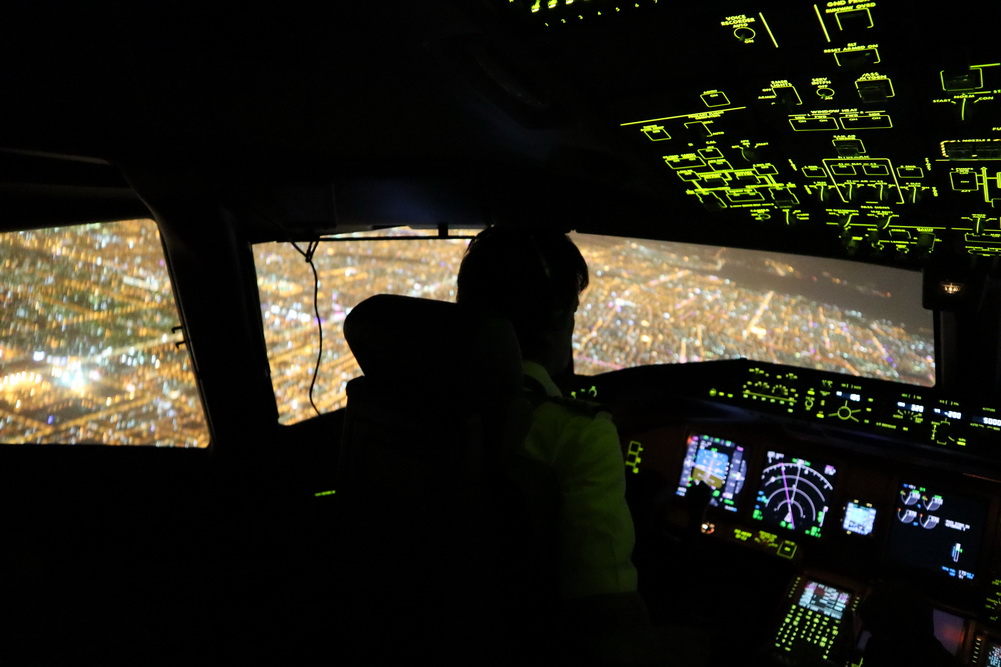 person in cockpit with big screen