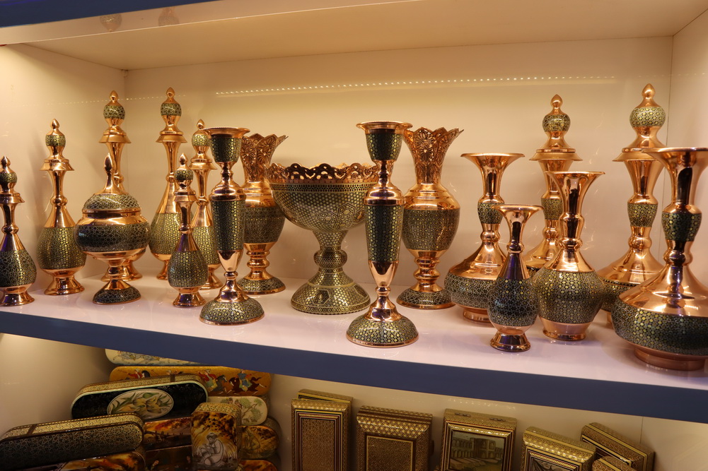 a shelf with gold and green vases