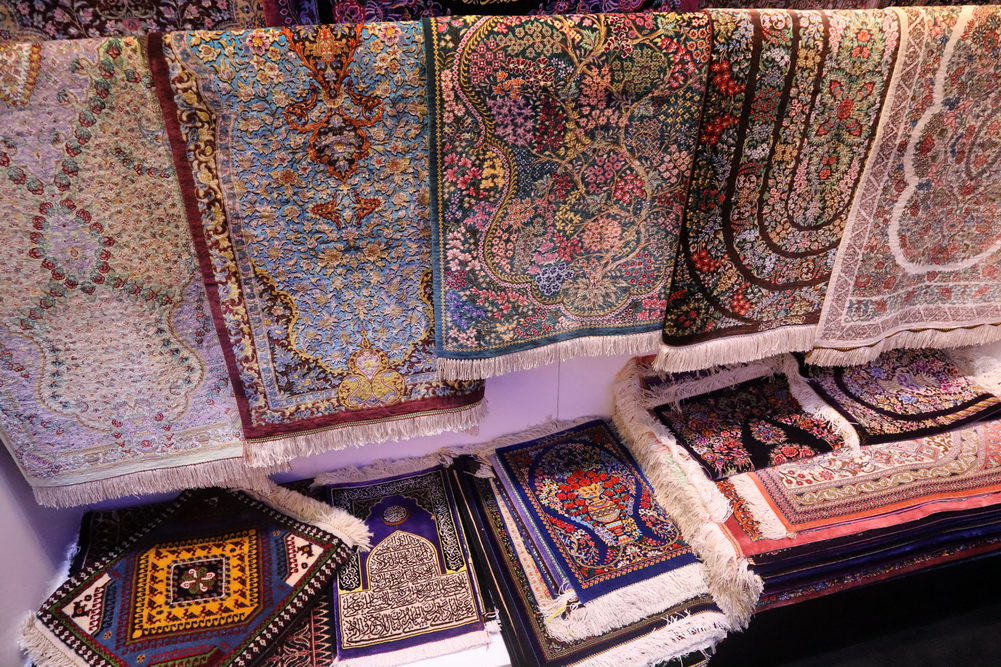 a group of colorful rugs on a shelf