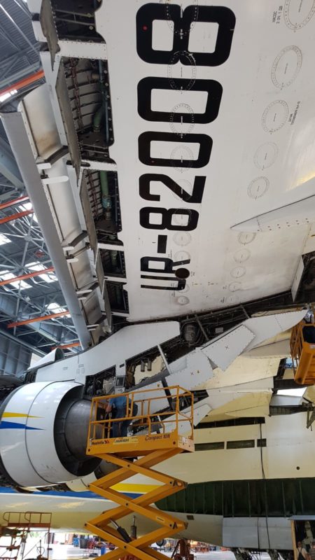 a white airplane with black numbers and a yellow ladder