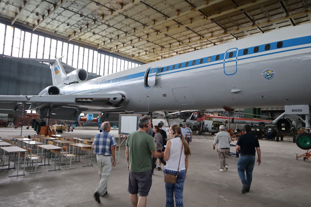 people standing in a hangar with a large airplane