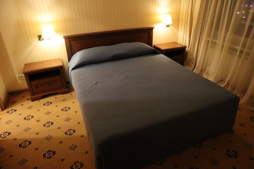 a bed with a wooden headboard and two lamps