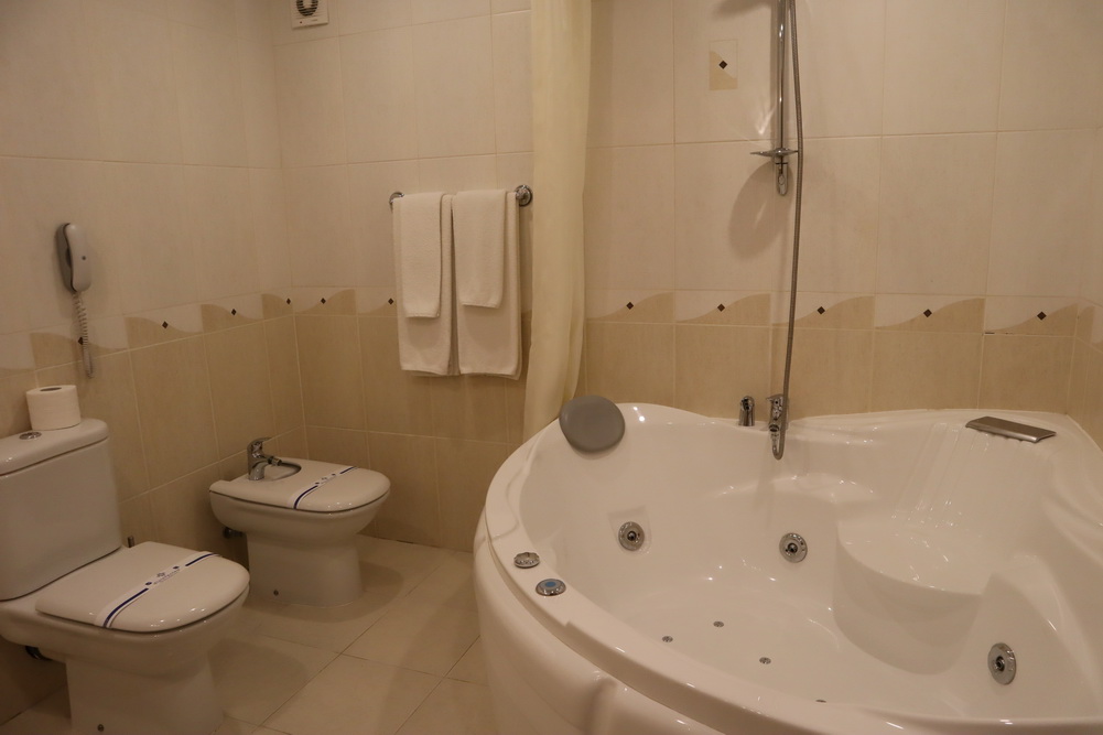 a bathroom with a tub toilet and toilet