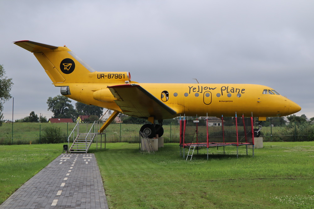 a yellow airplane on a grass field