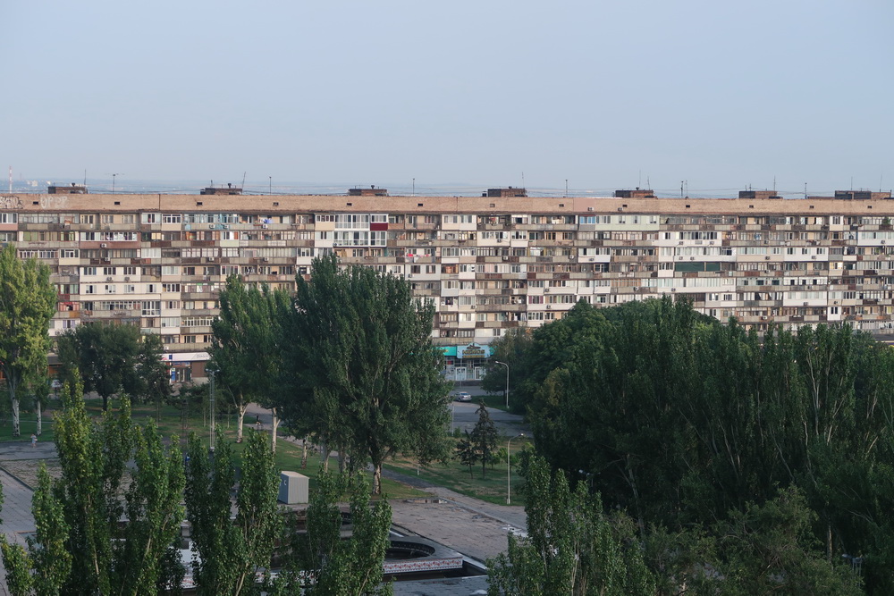 a large apartment building with trees in the background