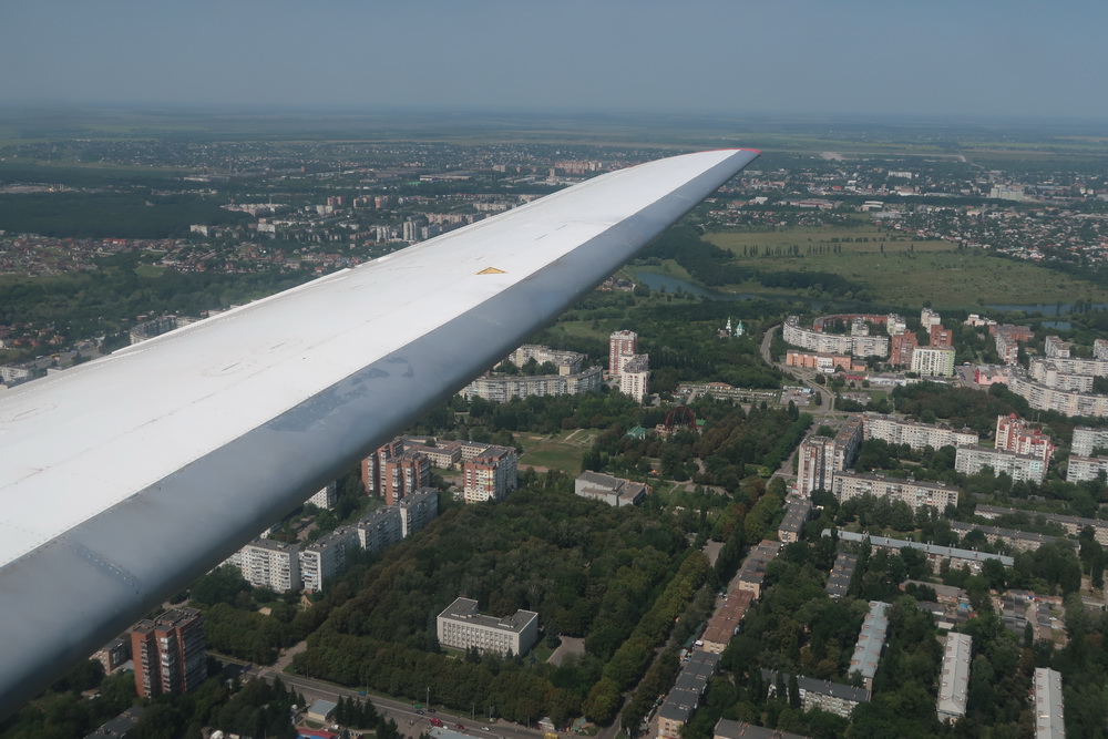 an wing of an airplane over a city