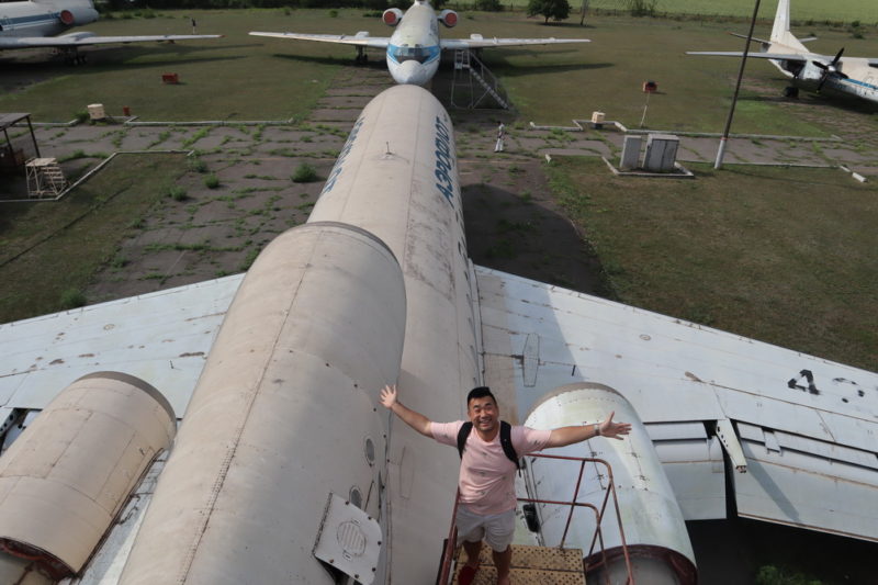 a man standing on a ladder next to an airplane