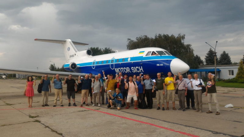 a group of people standing in front of a plane