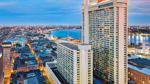 a large white building with a city in the background