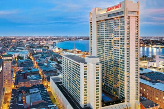 a large white building with a city in the background