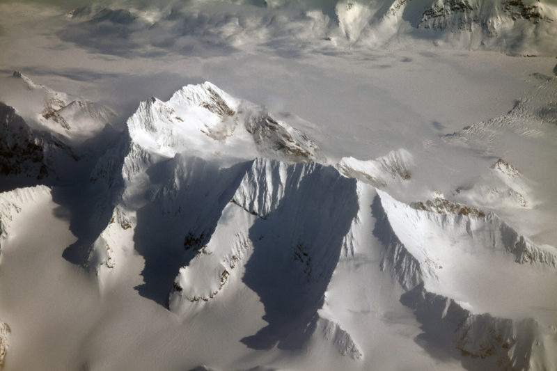 a snowy mountain range with clouds