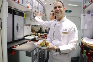 a man in a white coat holding a plate of food