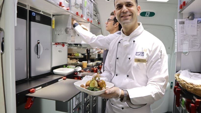 a man in a white coat holding a plate of food