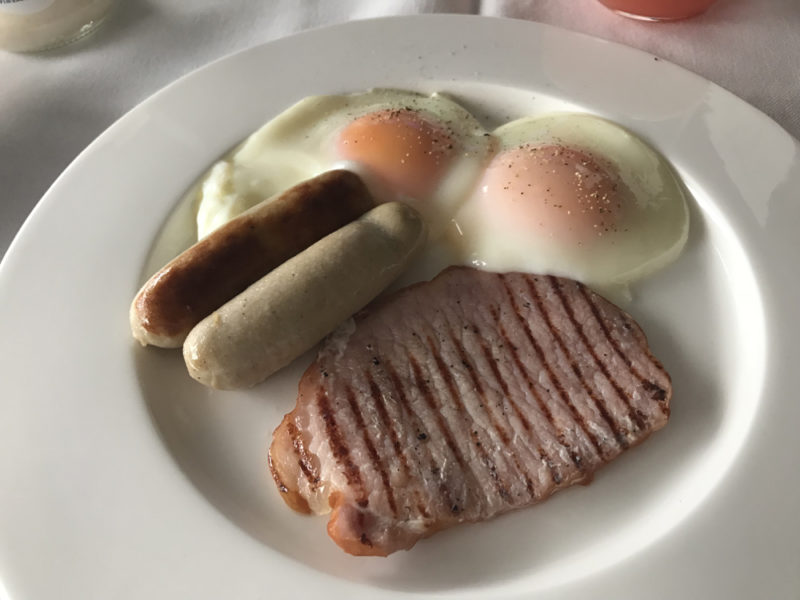 a plate of food with two eggs and sausages