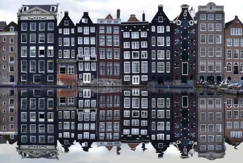 a row of buildings reflecting in water