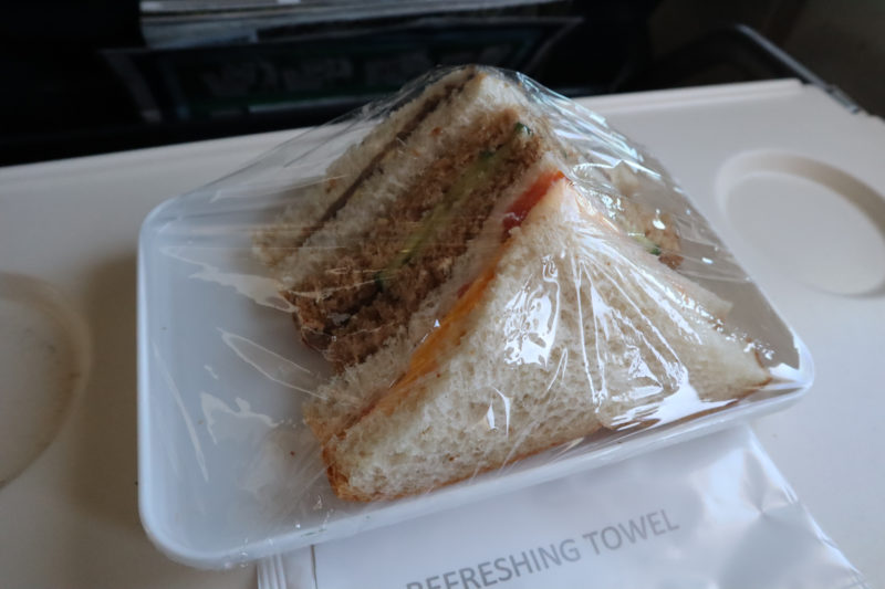 a sandwich wrapped in plastic on a plastic tray