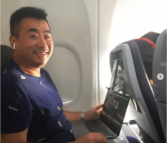 a man sitting in an airplane with a laptop