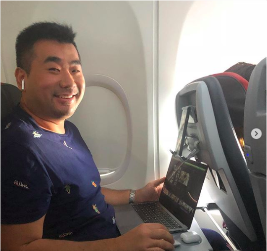 a man sitting in an airplane with a laptop