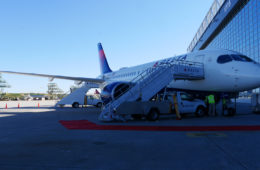 a plane with stairs and people standing next to it