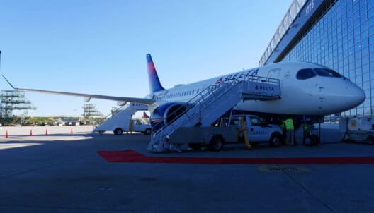 a plane with stairs and people standing next to it