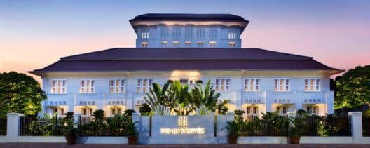 a building with a sign and plants