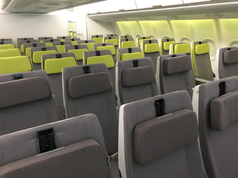 a row of grey and green seats in an airplane