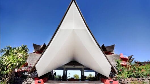 a triangular shaped building with a red wall and blue sky