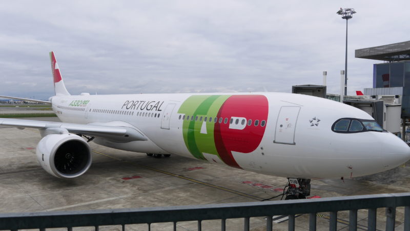 a white airplane with a green and red logo on it
