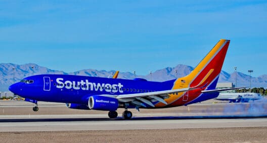 a blue and orange airplane on a runway