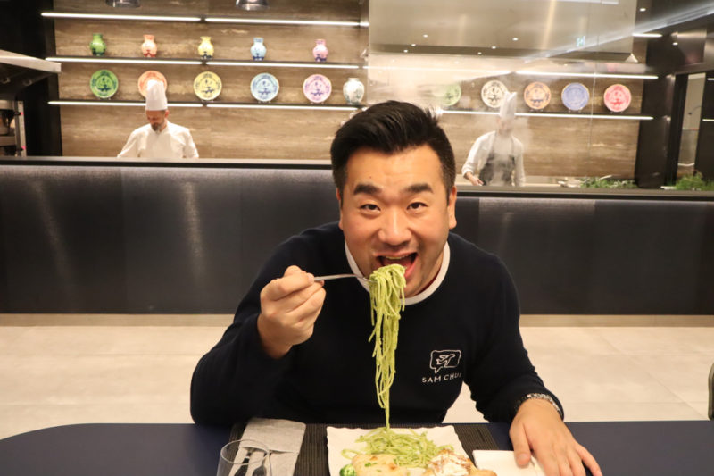 a man eating noodles with a fork