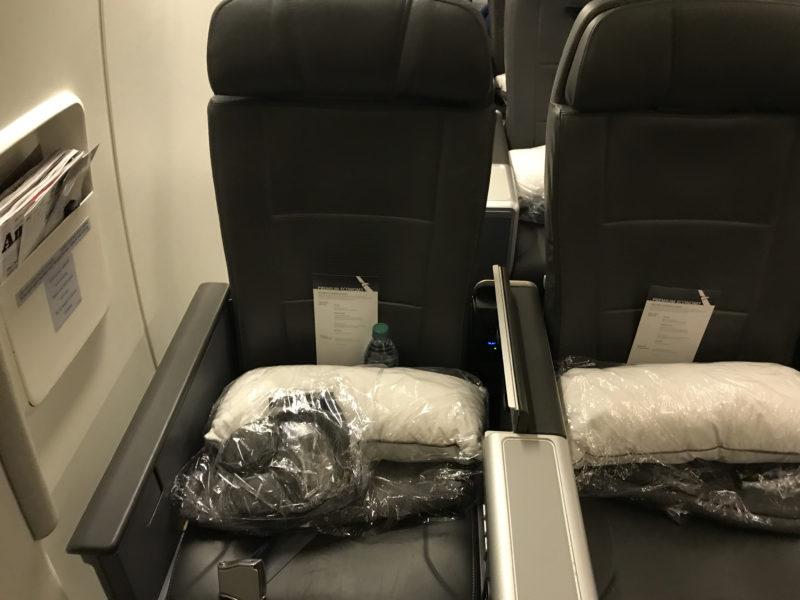 a seat with a bag of pillows and a bottle of water