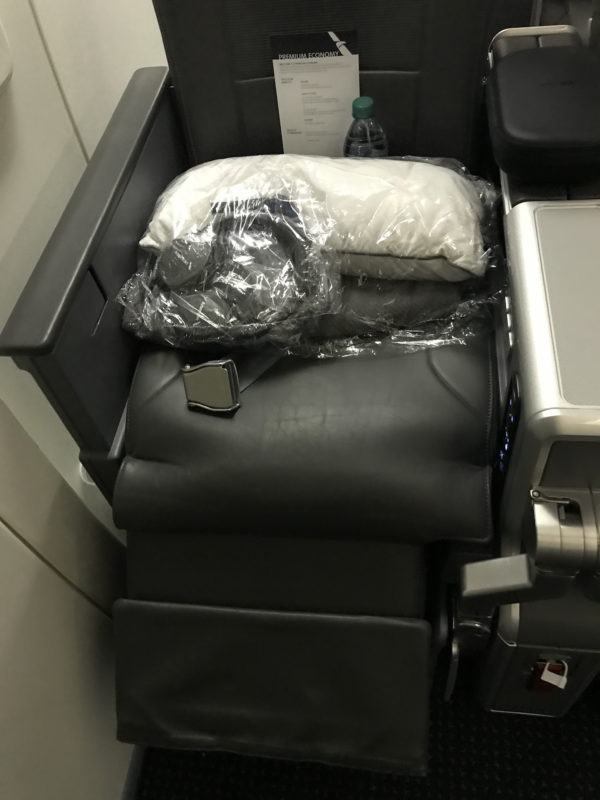 a seat with a bag and a bottle of water on it