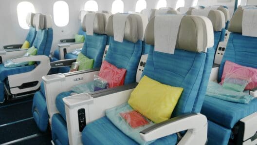 a row of blue chairs with pillows on the side