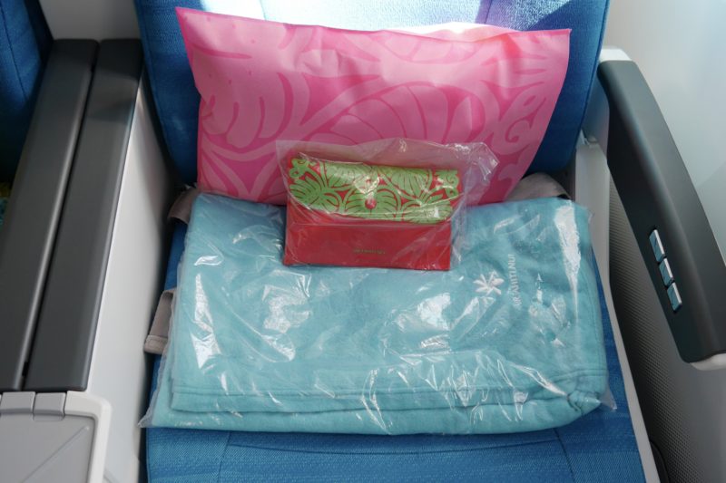 a blue towel and a pink pillow on a blue seat