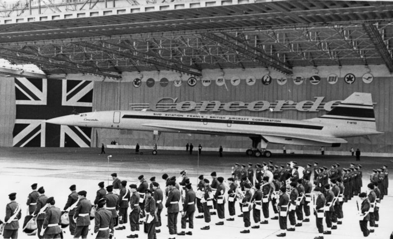a group of people standing in front of a plane