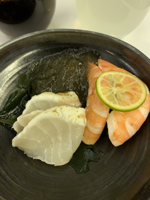 a bowl of seafood with a lime wedge