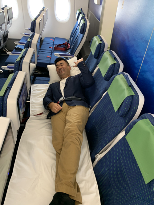 a man lying on a bed in an airplane