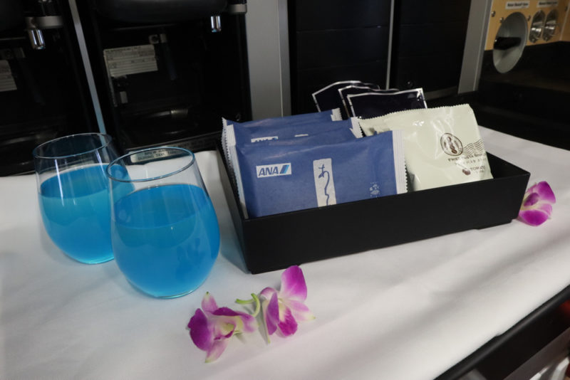 a tray of blue drinks and a pair of packets