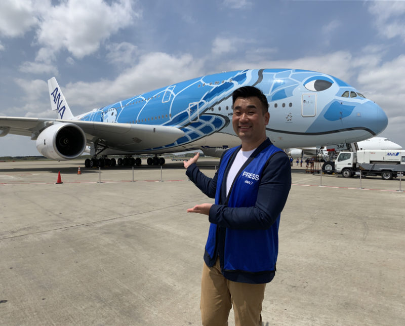 a man standing in front of a large airplane