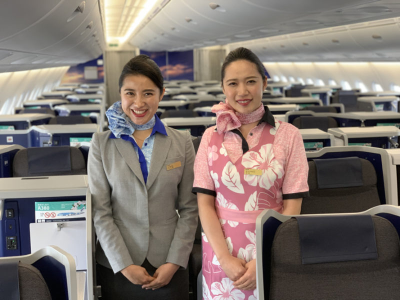 two women standing in an airplane