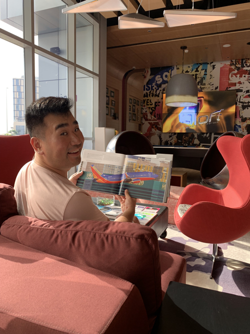 a man sitting on a couch holding a magazine