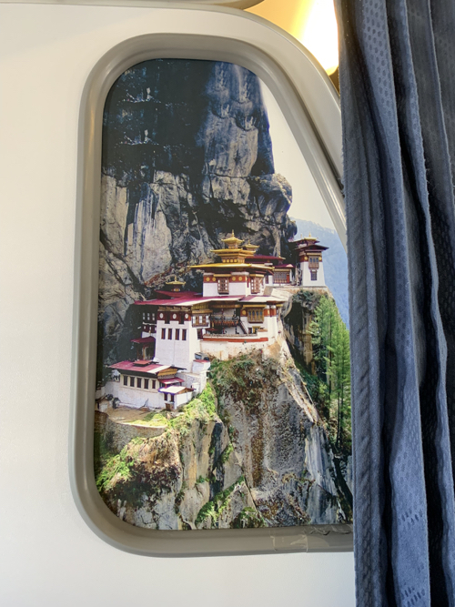 a window with a picture of a building on a mountain