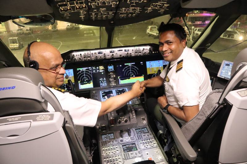 two men shaking hands in a cockpit