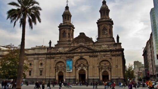 a large building with towers and people walking around