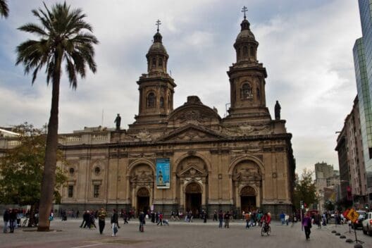 a large building with towers and people walking around