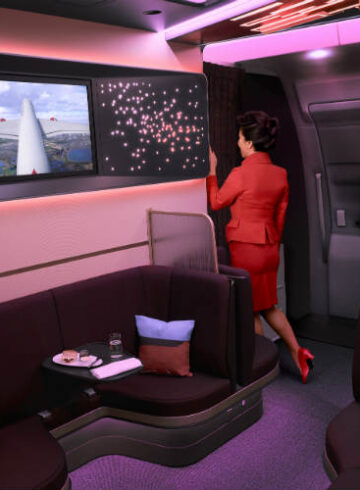 a woman in a red suit standing in a cabin