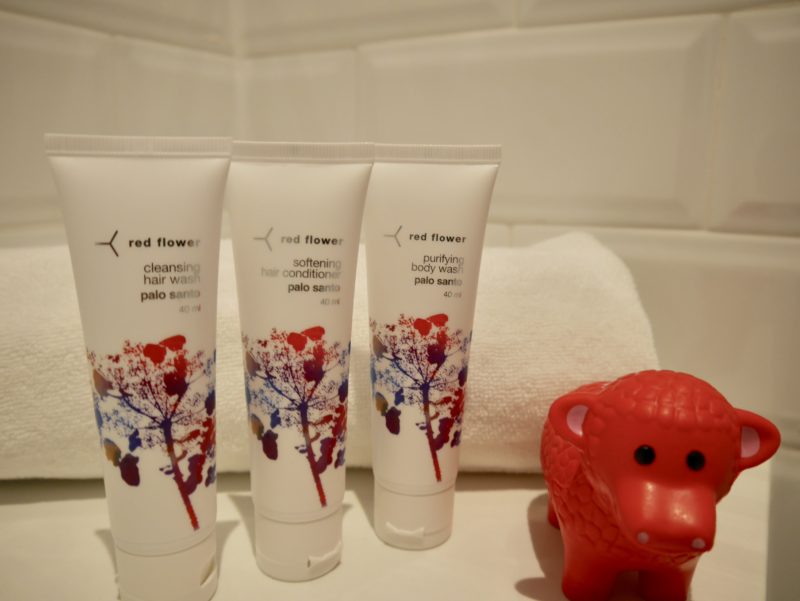 a group of white tubes with red and blue designs on them next to a towel and a red toy